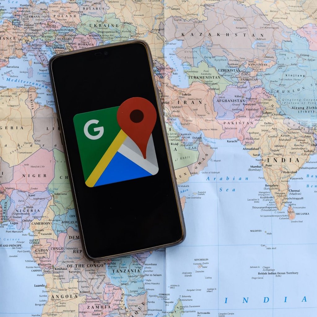 smartphone con Google My Business, appoggiato su cartina geografica